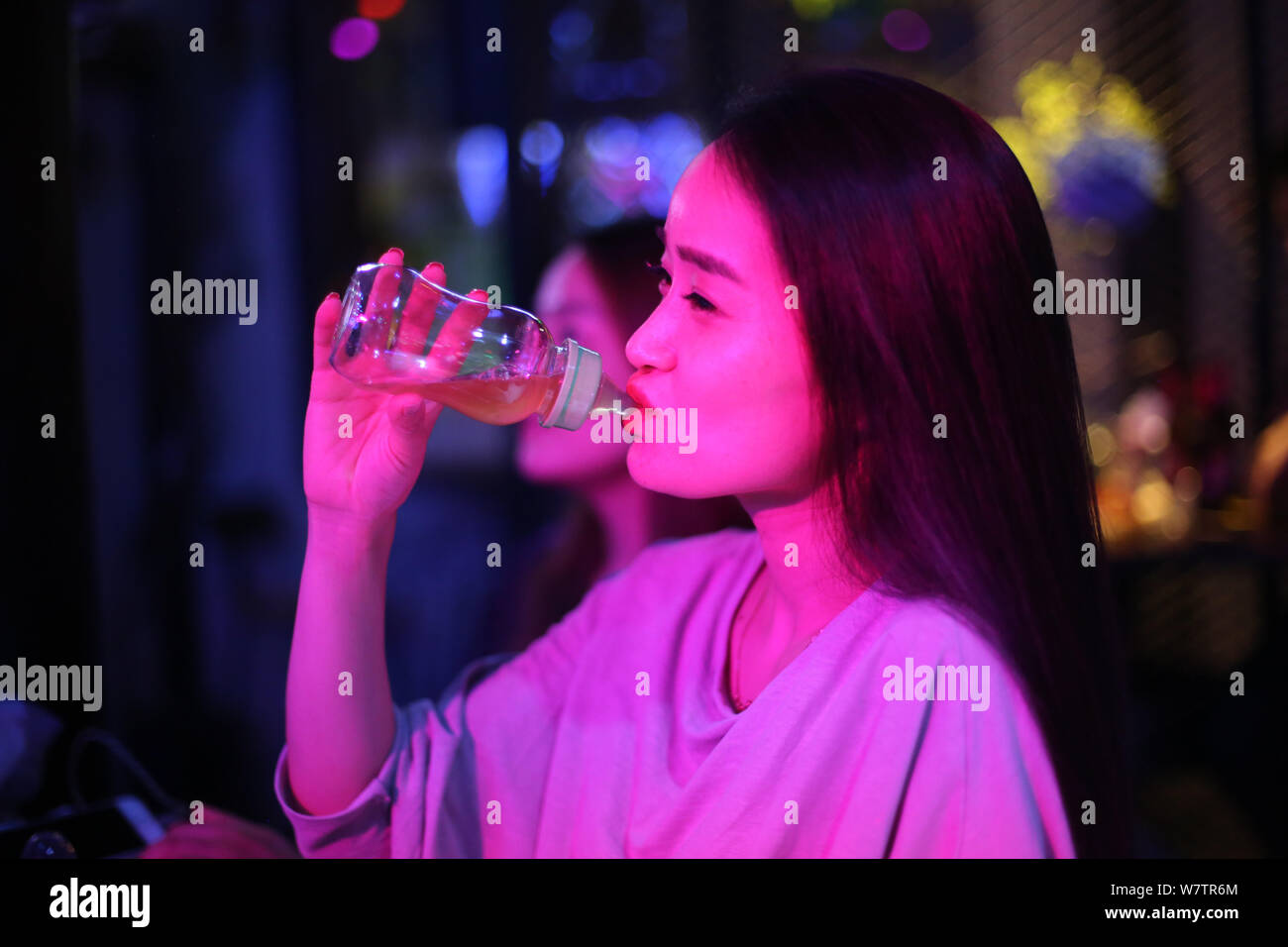 Una giovane donna cinese gode di birra con una plastica biberon preparato per contrassegnare la nazionale di promozione allattamento al seno di giorno in un bar di Wuxi, est Chi Foto Stock