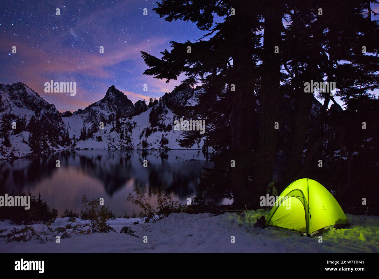 Tenda illuminata di notte dopo un inizio di nevicate invernali, con picco Kaleetan e Gem Lago, Vicino Snoqualmie Pass, Cascades, in Washington, Stati Uniti d'America, ottobre 2013. Foto Stock