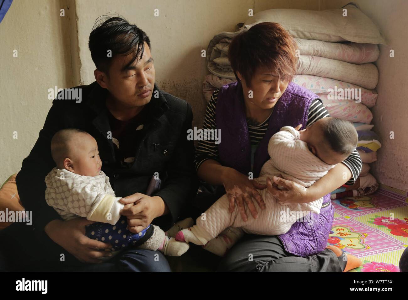 Genitori cinesi Wang Guojun, sinistra e Xu Shijia, che hanno utilizzato un sistema di lotteria per decidere quale di loro gravemente malato gemelli per salvare perché non p Foto Stock