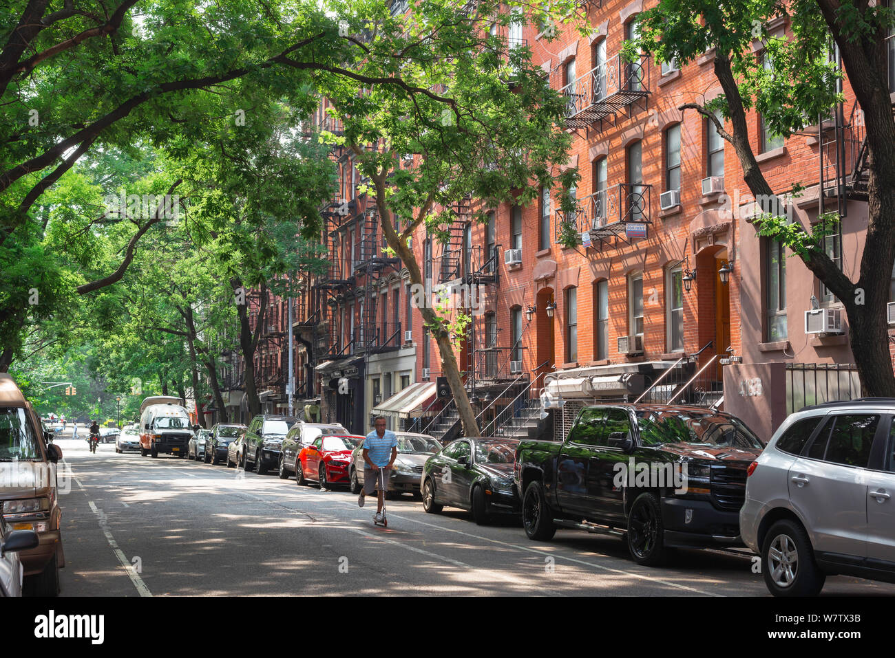 East Village di New York, vista in estate di un uomo a cavallo di un scooter lungo St Marks posto al centro dell'East Village di New York City, Stati Uniti d'America Foto Stock