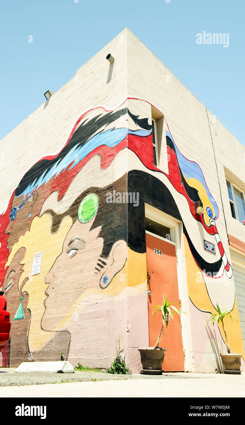 Worm occhio della vista di un enorme colorati graffiti a parete di tipo segno arte su un angolo della costruzione in entrata a un indefinito barberia di Pittsburg, California Foto Stock
