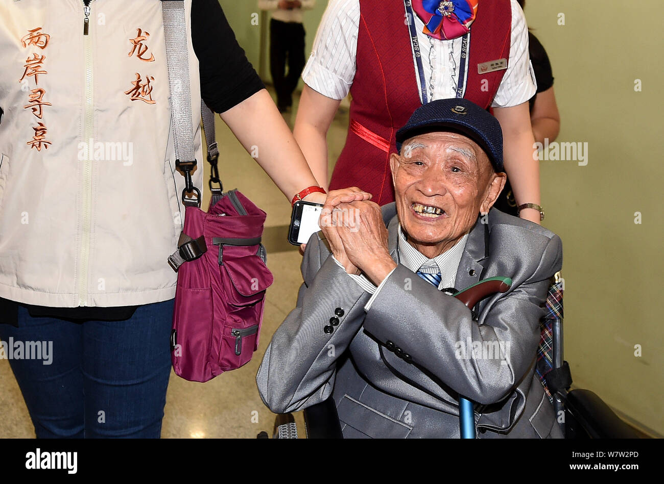 Il 97-anno-vecchio veterano cinese Hu Dingyuan reagisce al pubblico in una sedia a rotelle come egli arriva a Chengdu Shuangliu Aeroporto Internazionale di Chengdu, Foto Stock