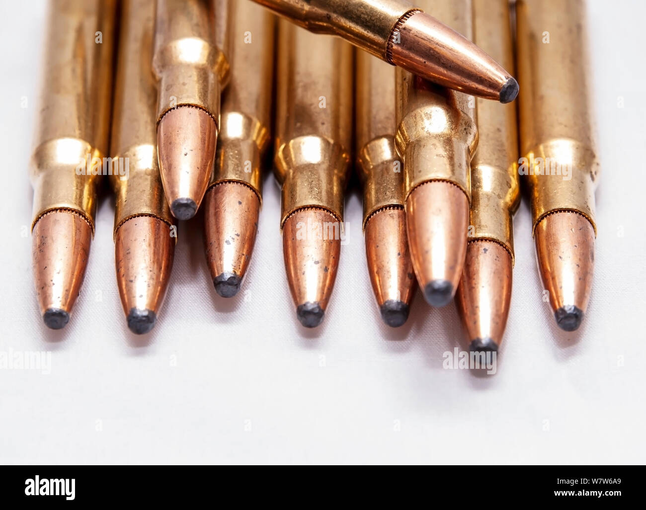 Una chiusura del fucile in ottone i proiettili usati per la caccia su sfondo bianco Foto Stock