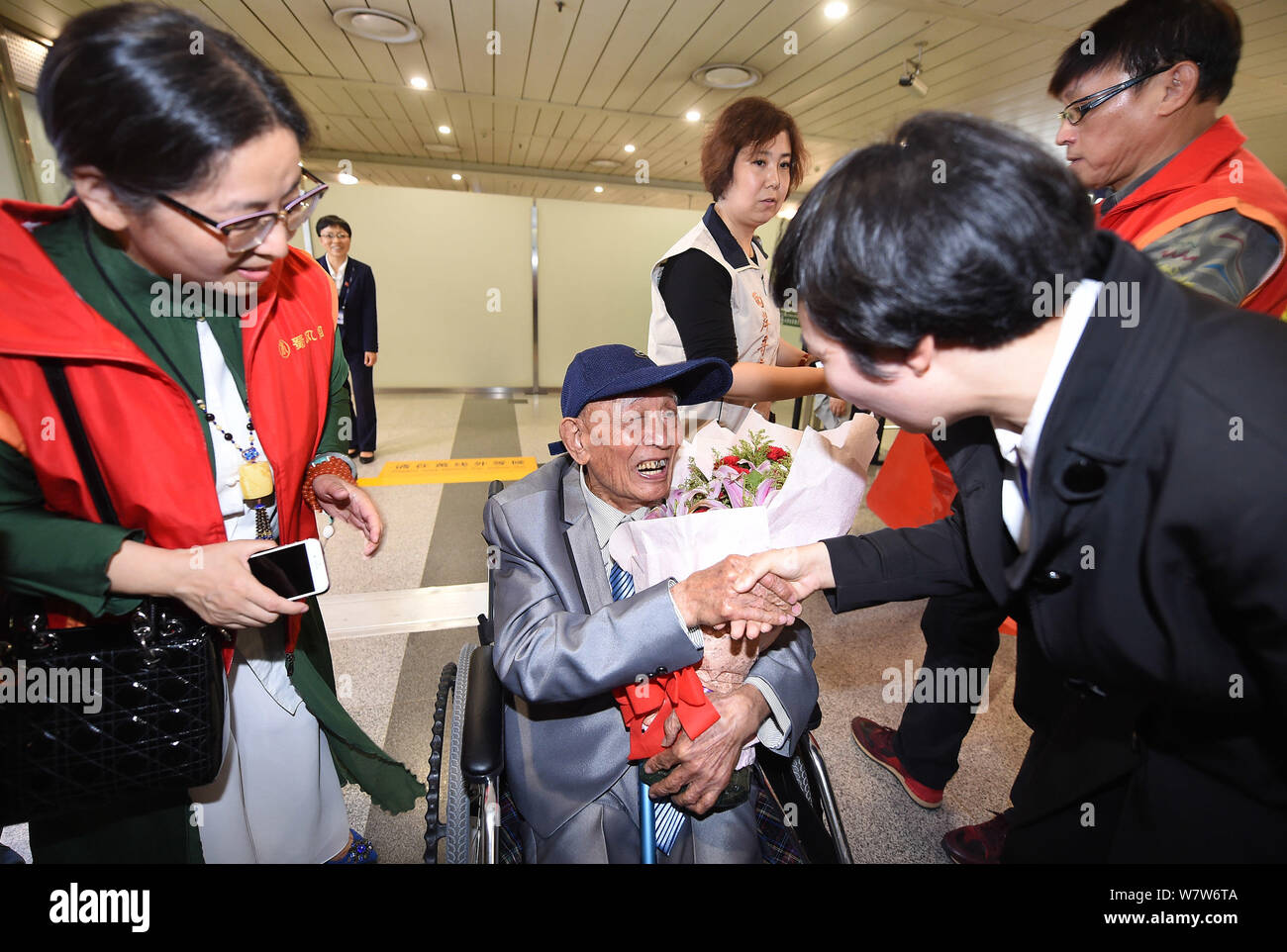 Il 97-anno-vecchio veterano cinese Hu Dingyuan scuote le mani con un Jounalist che lo aiuta a trovare la sua famiglia in una sedia a rotelle a Chengdu Shuangliu Ospiti int Foto Stock