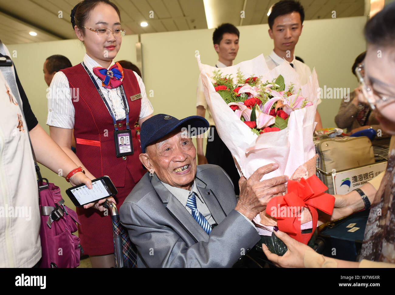 Il 97-anno-vecchio veterano cinese Hu Dingyuan è raffigurato in una sedia a rotelle come egli arriva a Chengdu Shuangliu Aeroporto Internazionale di Chengdu, southwes Foto Stock