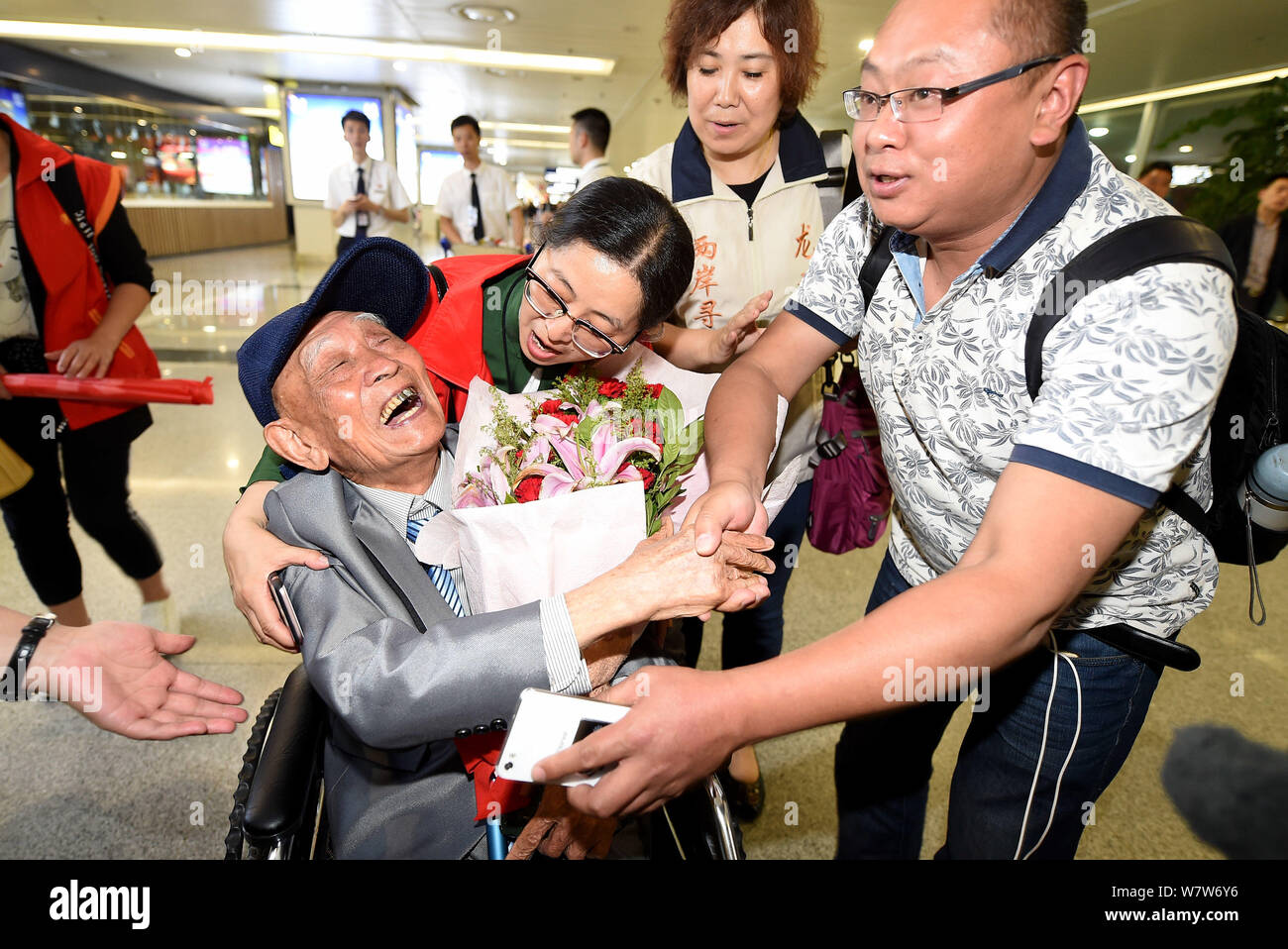 Il 97-anno-vecchio veterano cinese Hu Dingyuan scuote le mani con un Jounalist che lo aiuta a trovare la sua famiglia in una sedia a rotelle a Chengdu Shuangliu Ospiti int Foto Stock