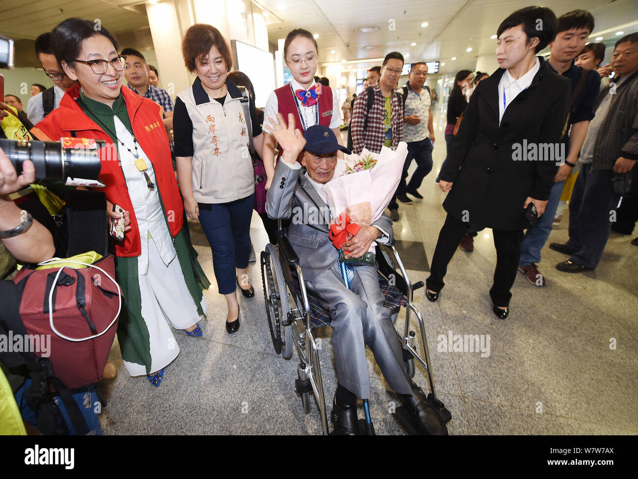 Il 97-anno-vecchio veterano cinese Hu onde Dingyuan al pubblico in una sedia a rotelle come egli arriva a Chengdu Shuangliu Aeroporto Internazionale di Chengdu, Foto Stock