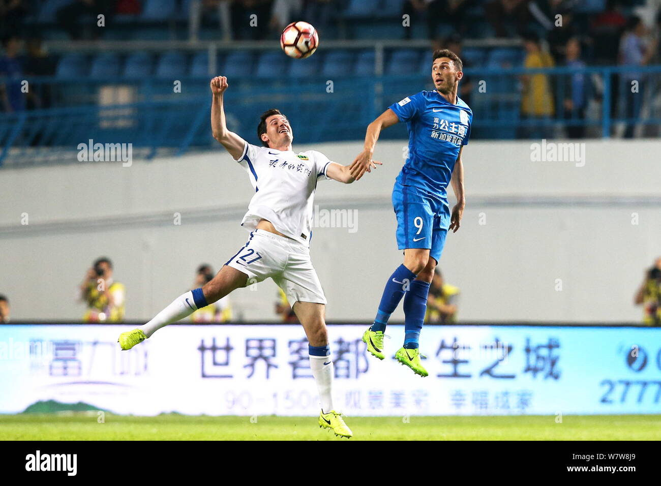 Greco di football australiano player Apostolos Giannou di Guangzhou R&F, destra, sfide Australian Football player Ryan McGowan di Guizhou Zhicheng in Foto Stock