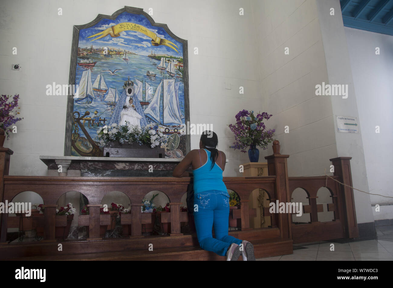 Donna che prega per la Virgen de Regla, patrono della Afrocuban / Santeria chiesa di Regla, Havana, Cuba, ottobre 2011. Foto Stock