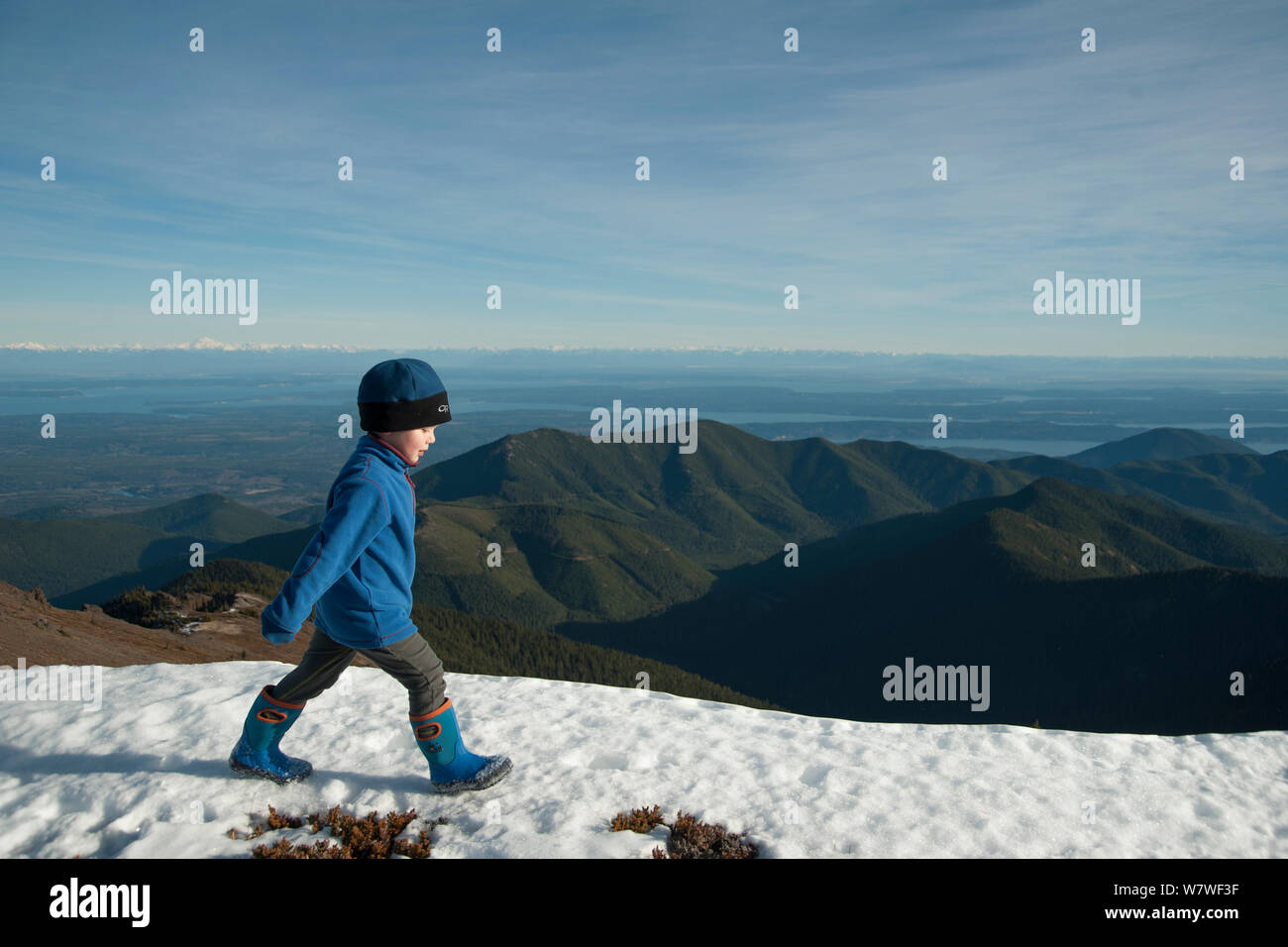 Giovane ragazzo toddler passeggiate sulla neve-coperta mountain summit, Mount Townsend, Northwest Olympic National Park, Penisola Olimpica, Washington, Stati Uniti d'America. Novembre 2013. Foto Stock