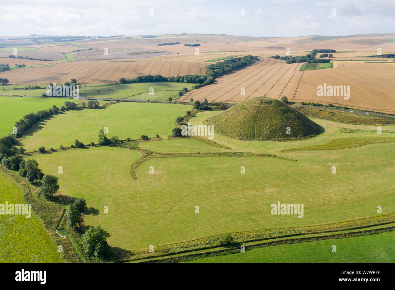 Silbury Hill, Nr Avebury, Wiltshire, Regno Unito. Il 6 agosto 2019. L antico man-made tumulo di Silbury Hill telai nella distanza come avviene la mietitura io Foto Stock