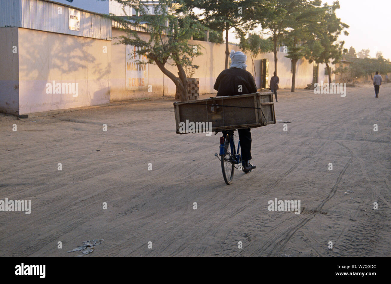 La mattina presto vista del ciclista su strada vuota, N&#39;Djamena, Ciad, 2002-2003. Foto Stock