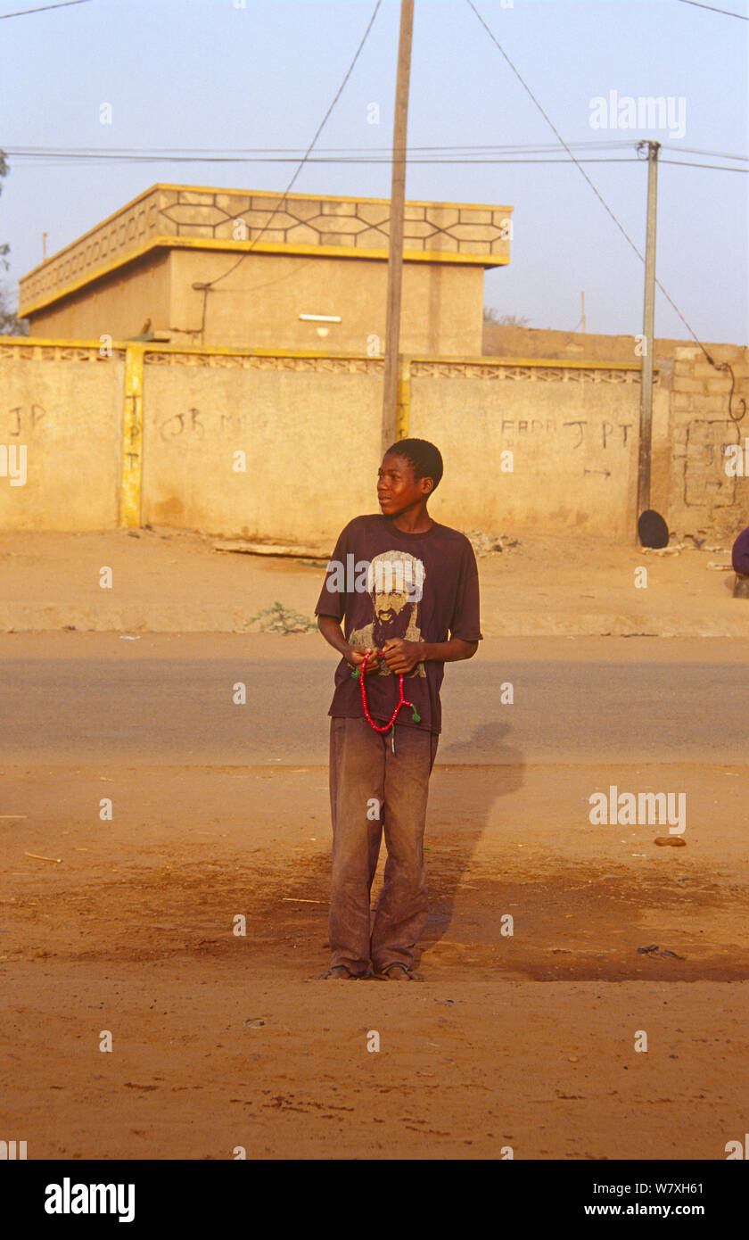 Giovane uomo in attesa di taxi indossando Osama bin Laden t shirt, Niger, 2003. Foto Stock