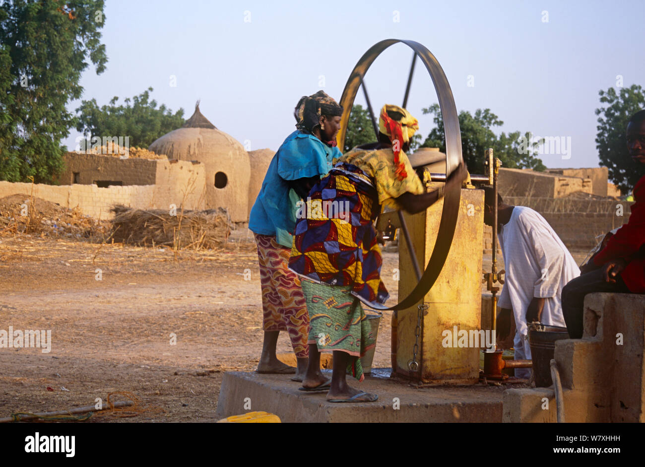 Donne locali utilizzando acqua pompa in Hausa village, Niger, 2004. Foto Stock