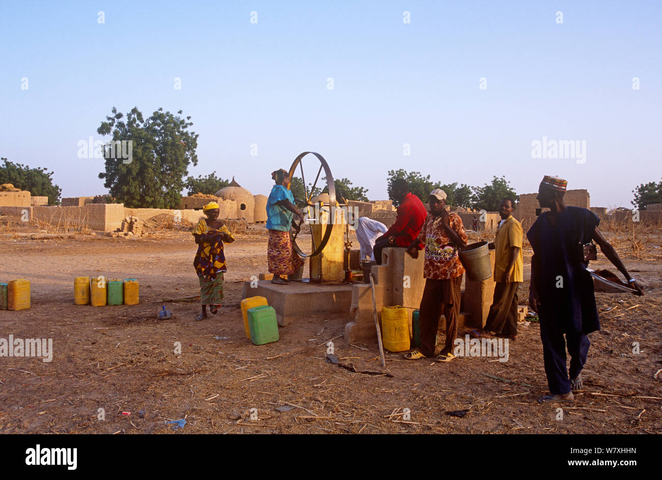 La popolazione locale utilizzando acqua pompa in Hausa village, Niger, 2004. Foto Stock