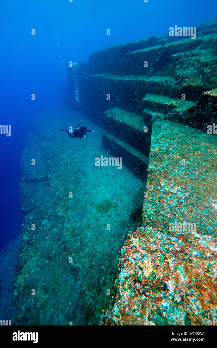 Diver esaminando la struttura in pietra arenaria di Yonaguni monumento sottomarino, Yonaguni, ad est del Mar della Cina, Giappone. Febbraio 2014. Foto Stock