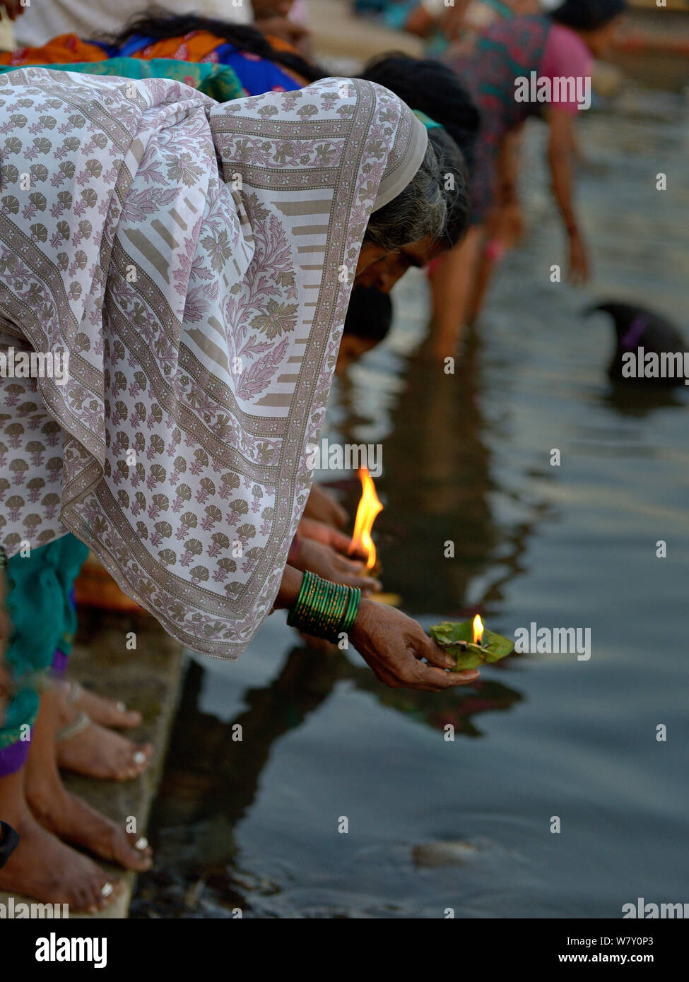 Persone immissione lanterne sul fiume, un offerta per il Gange durante il festival religioso. Varanasi, Uttah Pradesh, India, marzo 2014. Foto Stock
