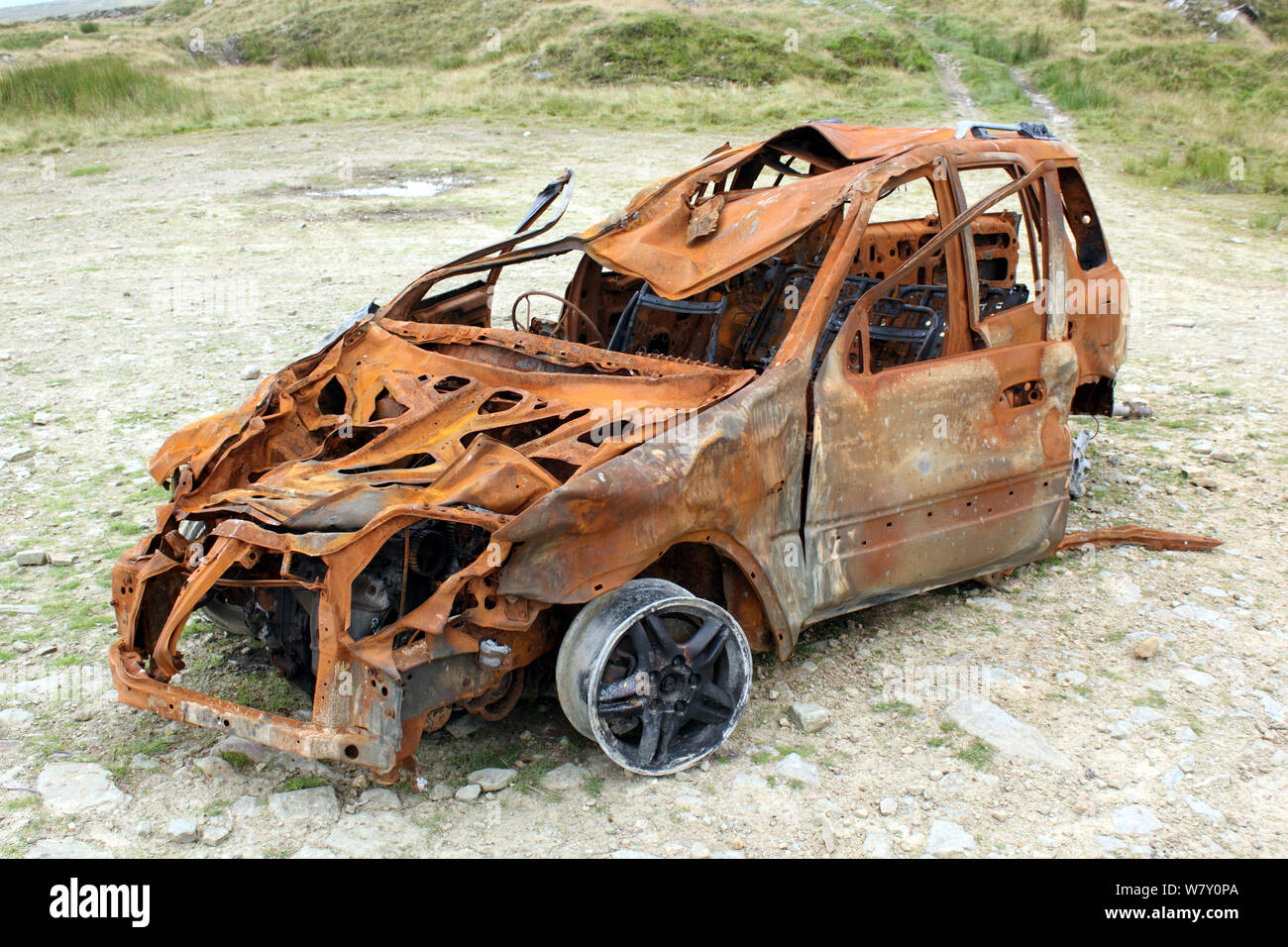 Vista di bruciato abbandonato auto rubate in posizione remota Foto Stock