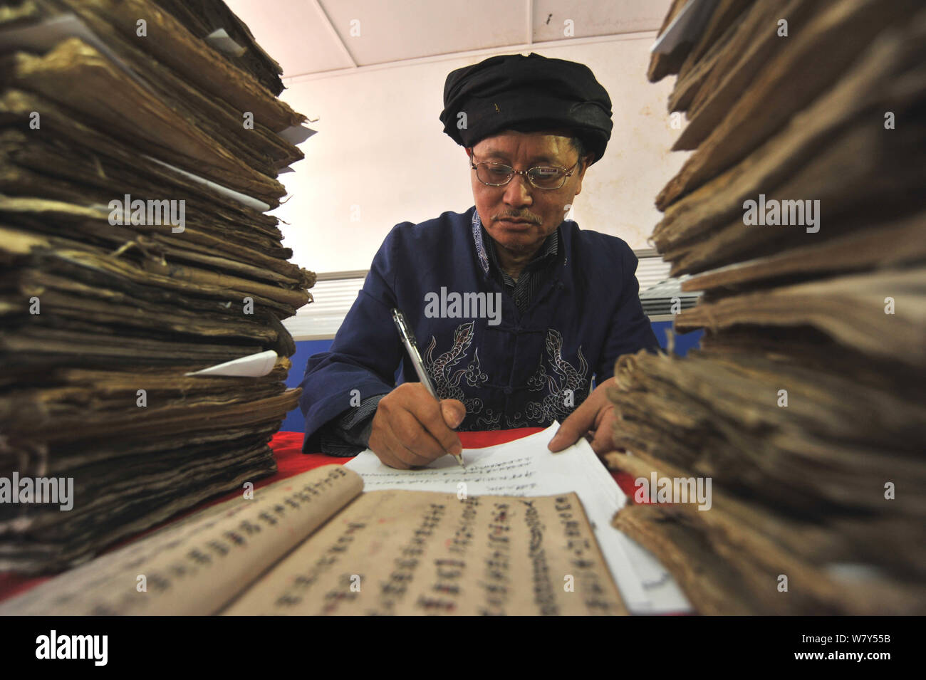 Uno studioso cinese Ordina libri di Shui script raccolti dalla gente del luogo in Cosmin Shui contea autonoma, a sud-ovest della Cina di Guizhou, 22 Marzo 2 Foto Stock