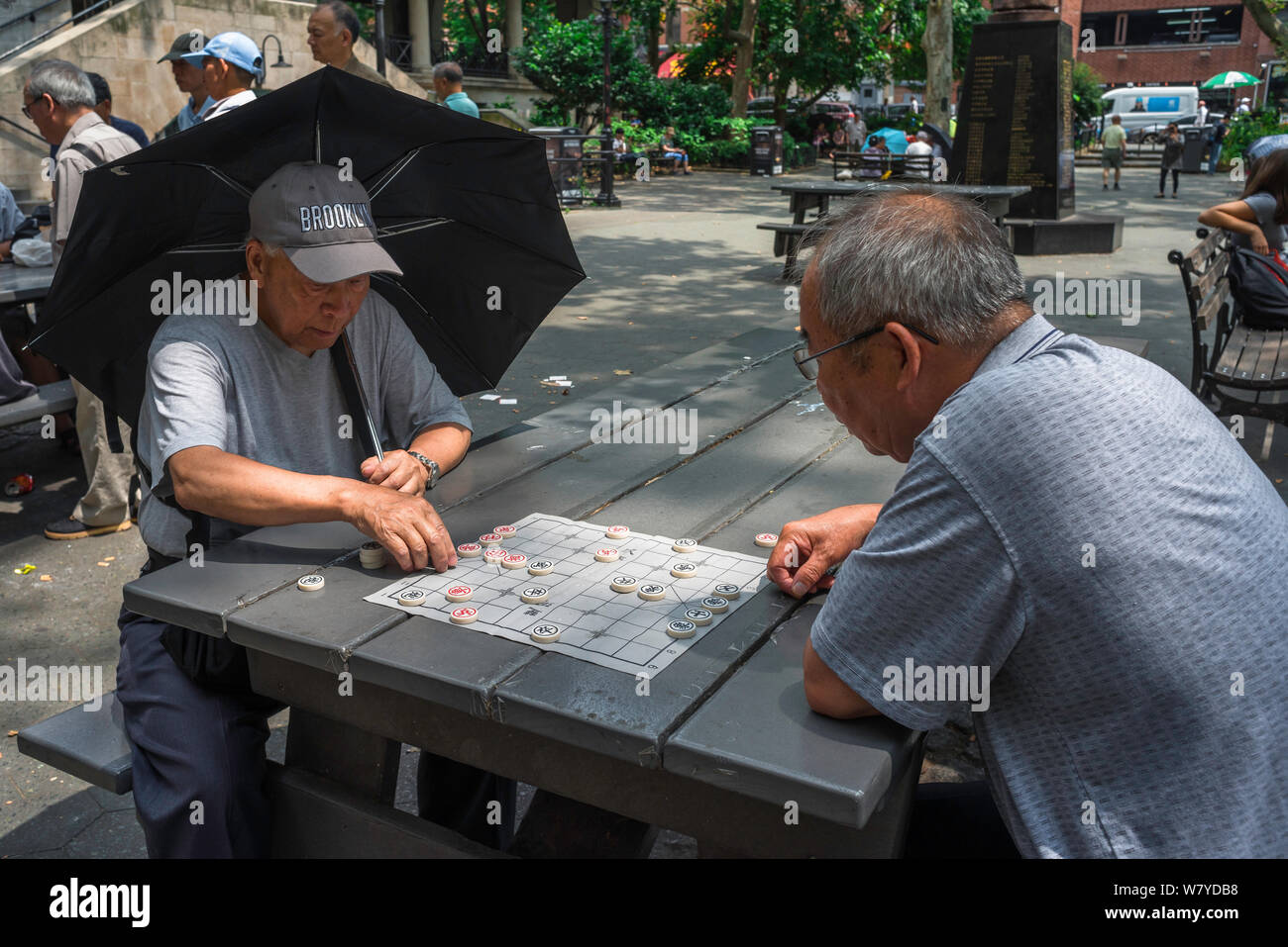 Scacchi cinesi, vista di due uomini che giocano Xiangqi, conosciuto anche come scacchi cinesi, a Columbus Park nel quartiere di Chinatown di New York City, USA Foto Stock
