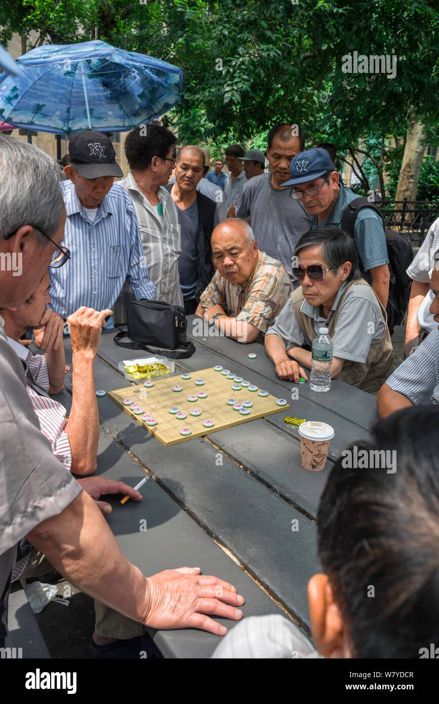 Xiangqi, vista degli uomini che guardano una partita di Xiangqi, conosciuta anche come scacchi cinesi, a Columbus Park nel quartiere di Chinatown di New York City, USA Foto Stock