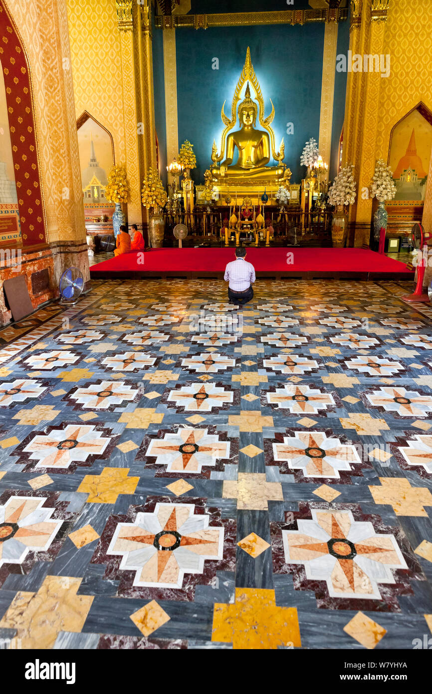 Uomo che prega alla statua del Buddha (chiamando la terra a testimoniare la postura) Wat Benchamabophit Dusitwanaram Ratchaworawiharn, Bangkok. Thailandia, settembre 2014. Foto Stock