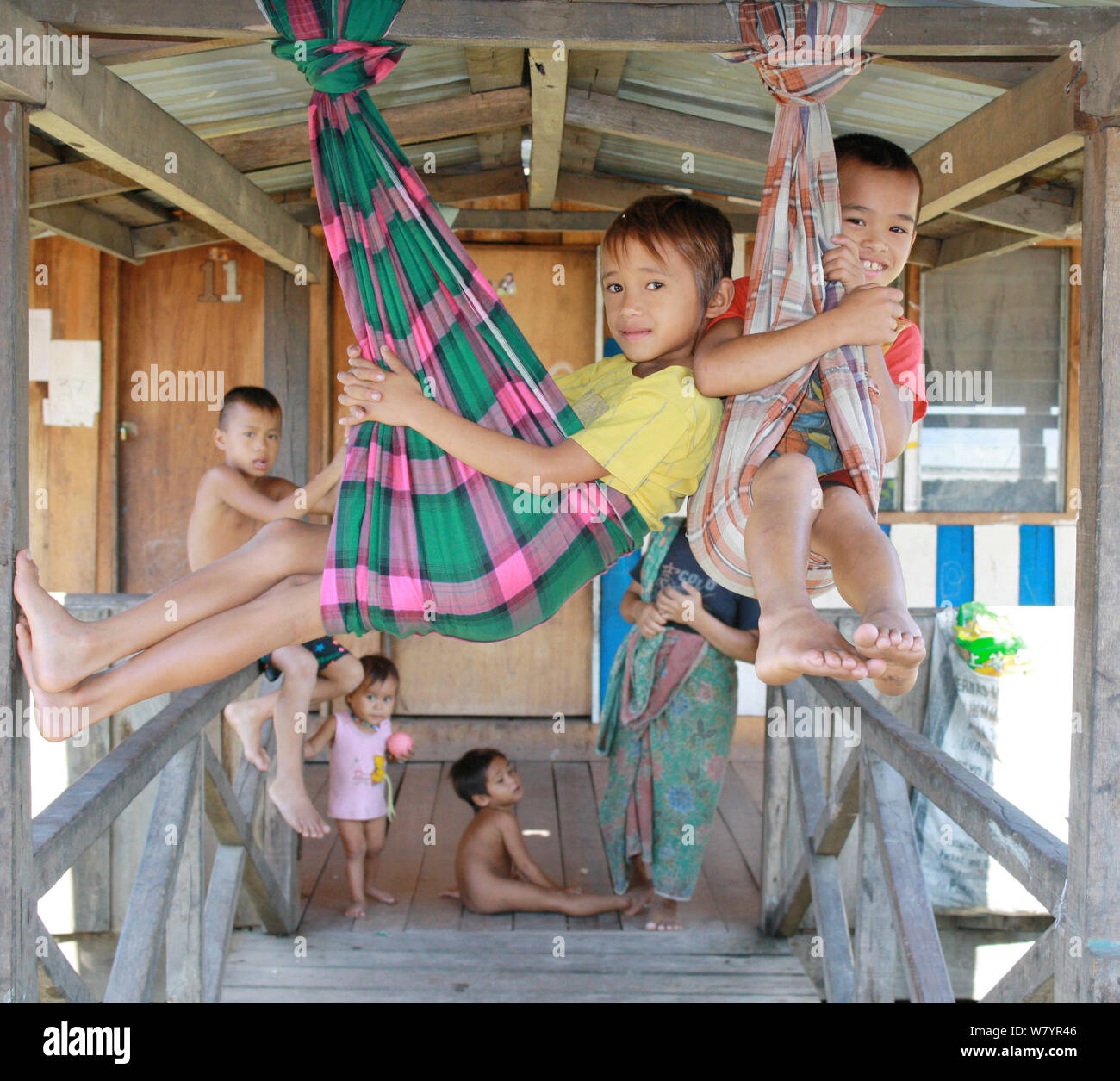 Dayak persone, bambini che giocano in longhouse, sfrattati da casa per la costruzione della diga, Sabah Borneo Malese. Luglio 2010. Foto Stock