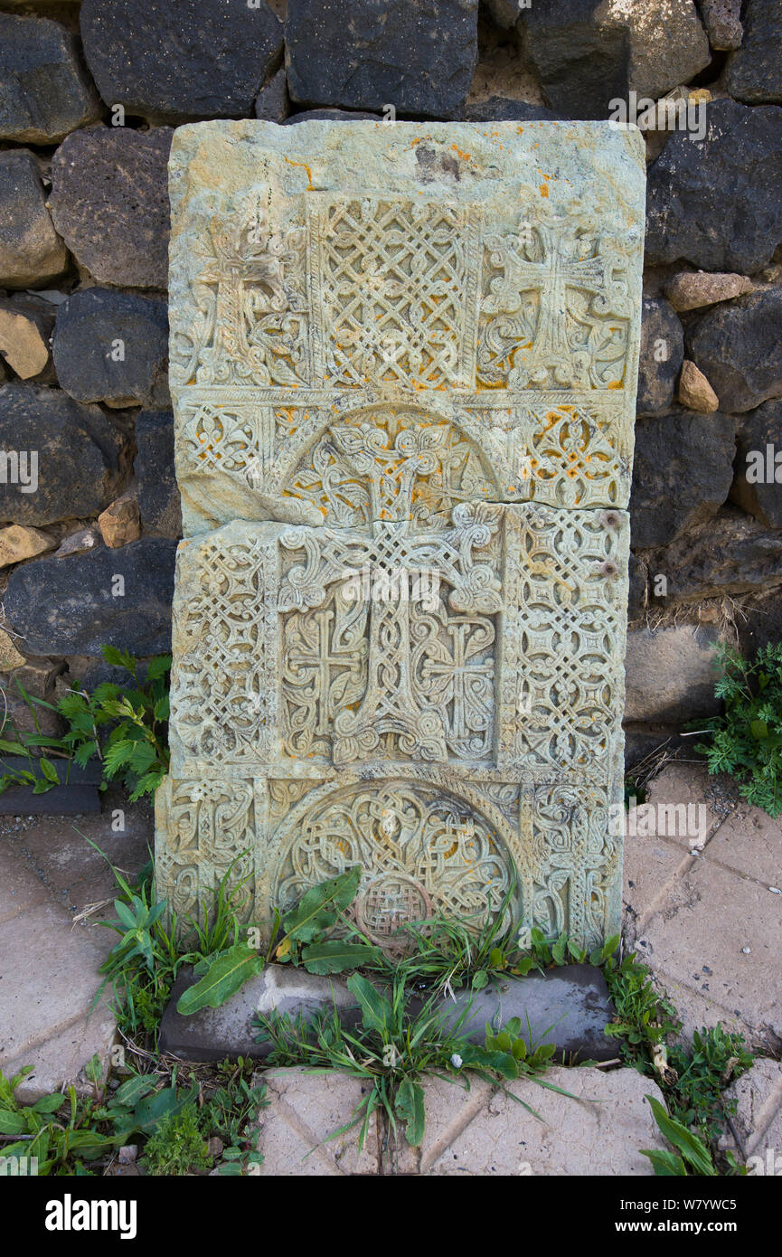 Croce di pietra (khachkar) collocati lungo la parete della chiesa, Armenia, maggio. Foto Stock