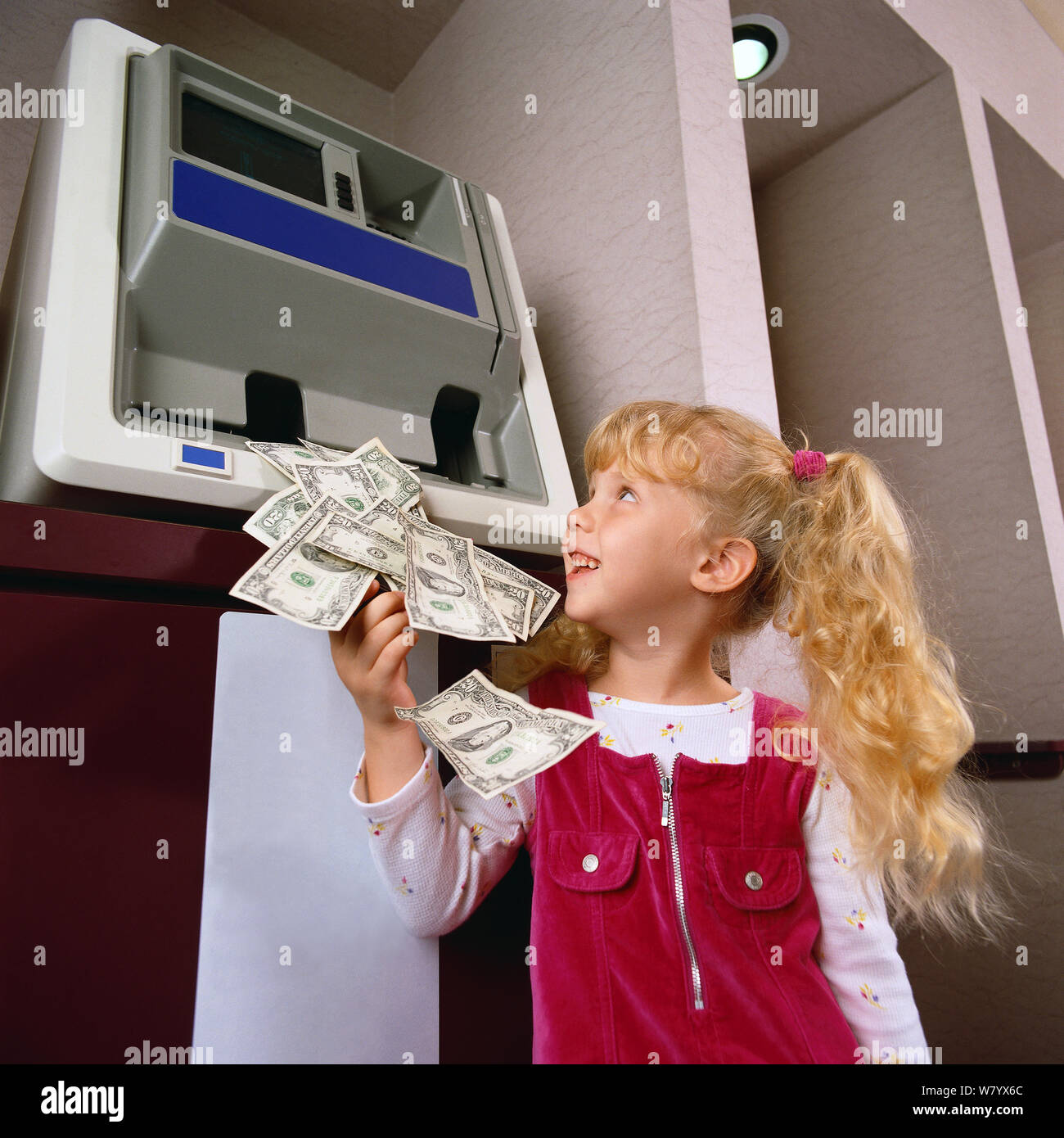 Bambino che ottiene i soldi dal bancomat Foto Stock