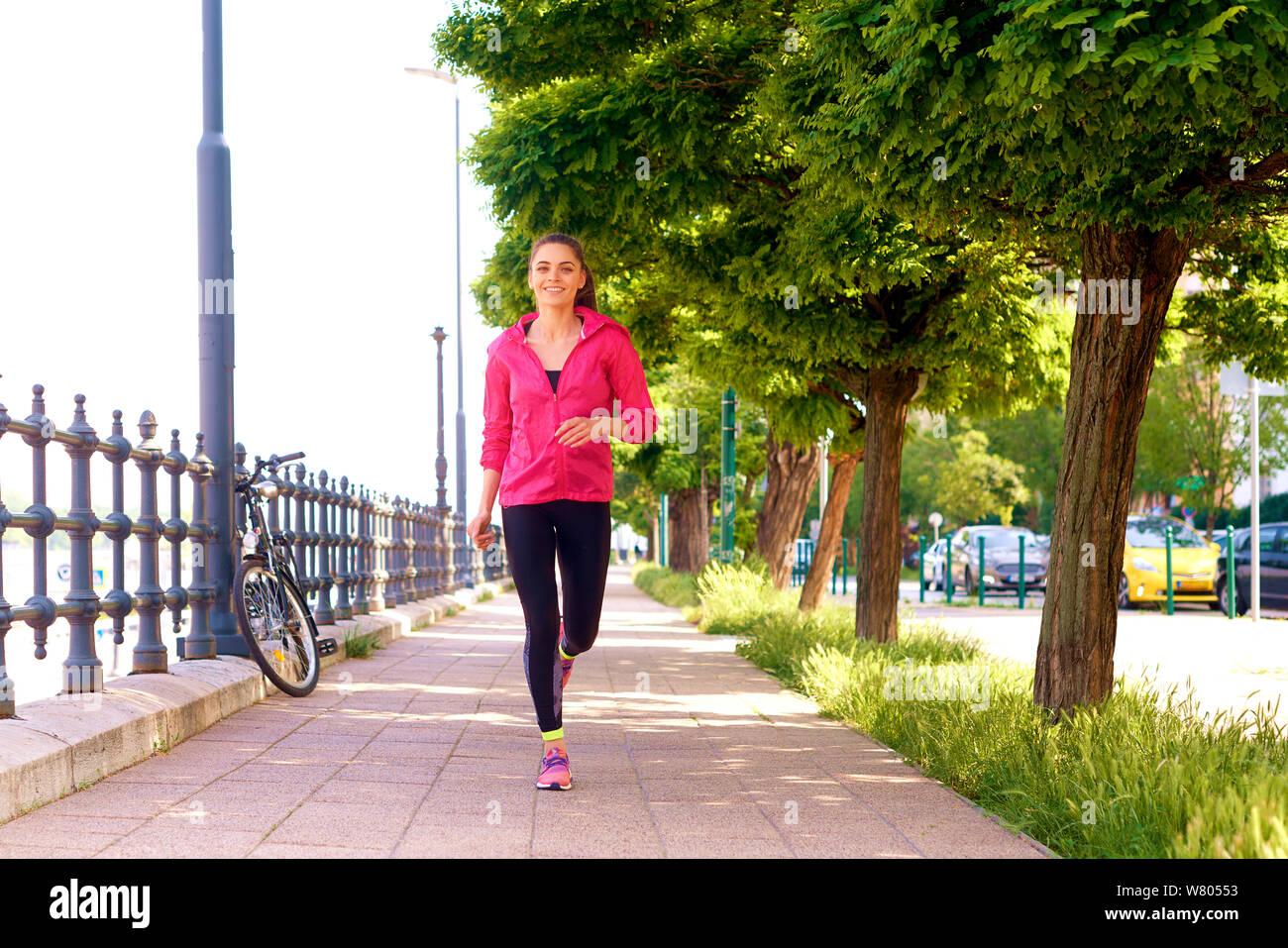 A piena lunghezza shot della giovane donna indossa sportwear mentre è in esecuzione la città. Foto Stock