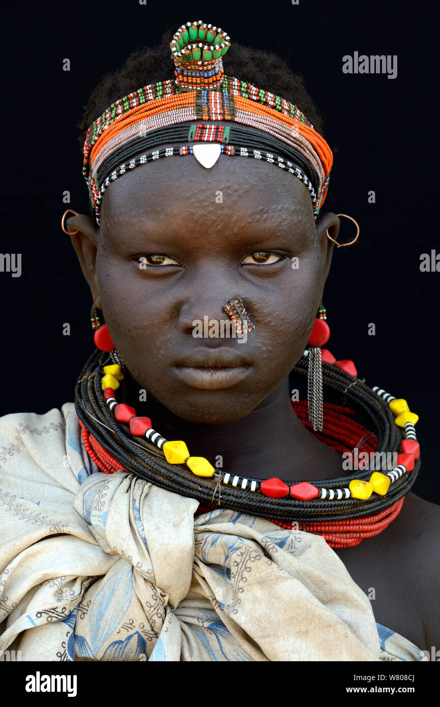 Giovane donna dalla tribù Toposa, con la pelle del viso scarificazione e testa tradizionale usura e gioielli, Valle dell'Omo, Etiopia, marzo 2015. Foto Stock