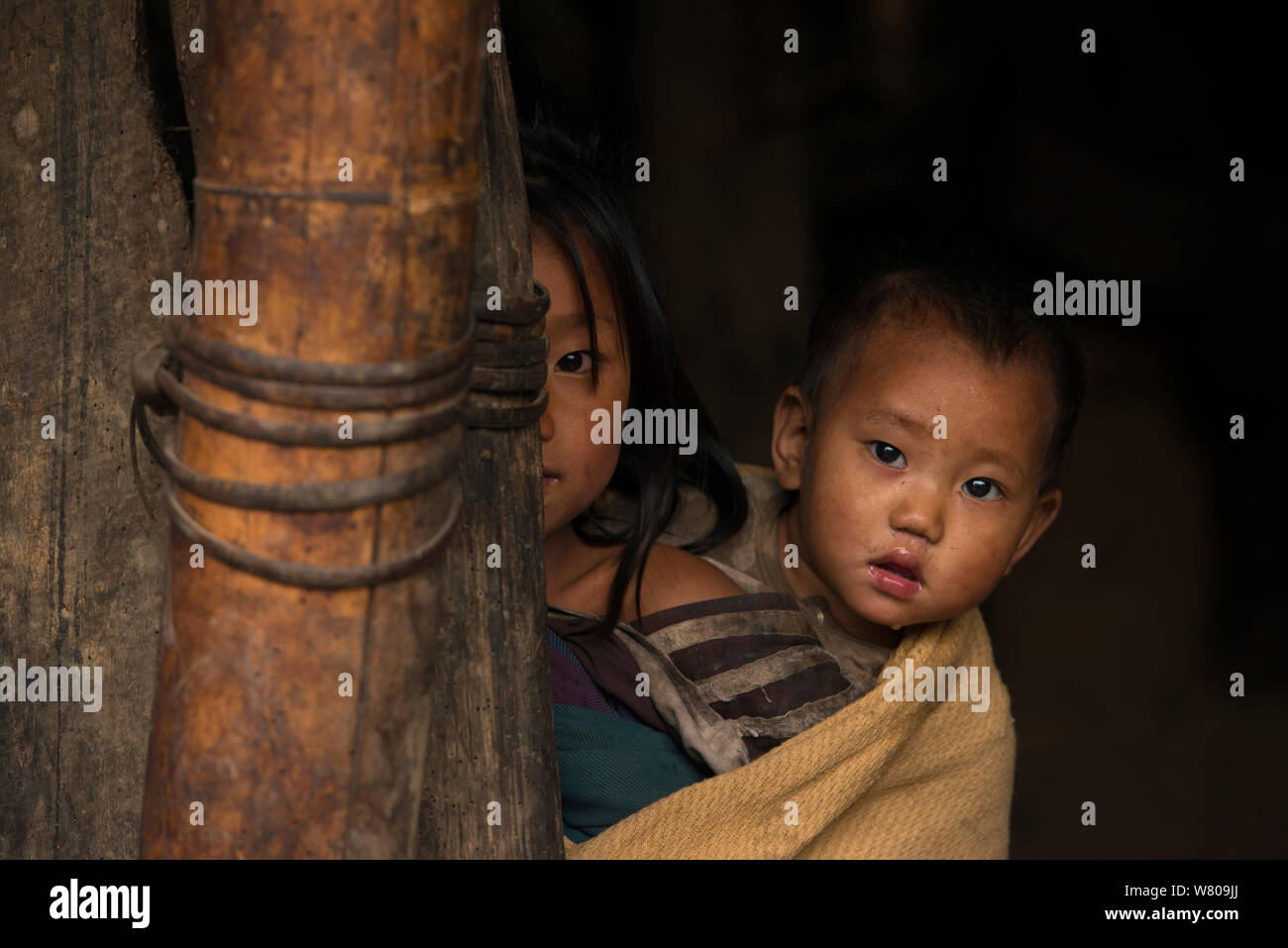 Konyak Naga bambini round di peering porta, Mon district, Nagaland, nord-est dell India, ottobre 2014. Foto Stock