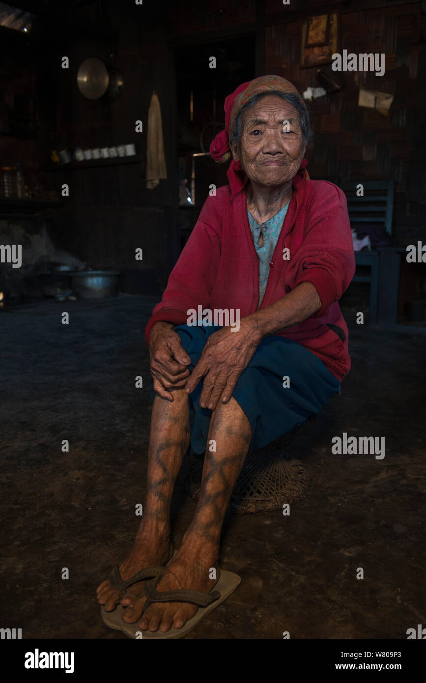 Ritratto di anziani Ao Naga donna con la gamba di tatuaggi. Ao Naga headhunting tribù. Mokokchung distretto. Il Nagaland, nord-est dell India, ottobre 2014. Foto Stock