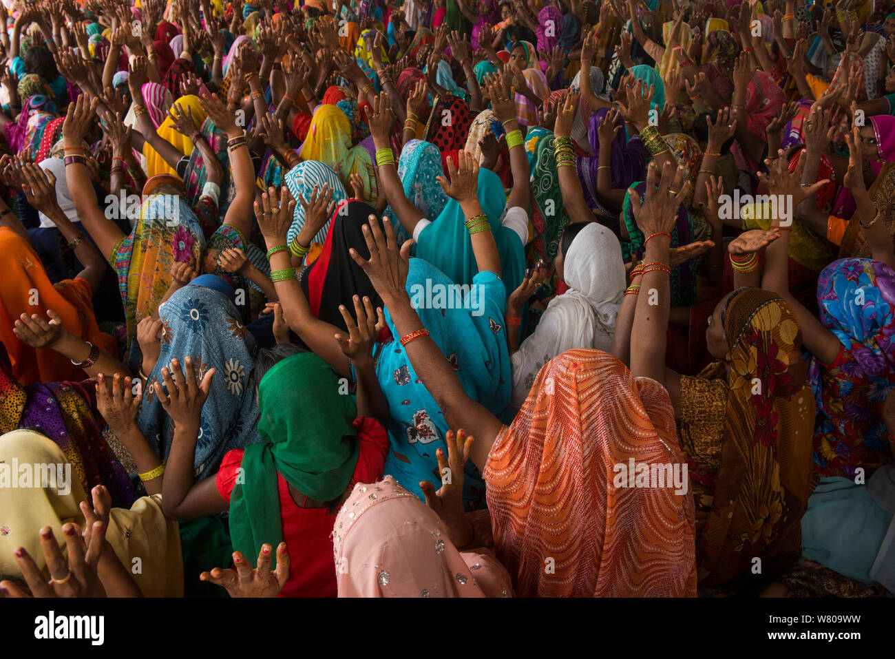 Le donne con le mani alzate al raduno religioso, Bateshwar Village, Distretto di Agra, Uttar Pradesh, India, ottobre 2014. Foto Stock
