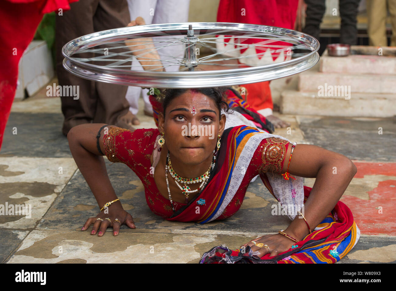 Hirja performer, equilibratura ruota di bicicletta sulla testa, Hijra sono transgender gente legalmente riconosciuto come un terzo sesso in India. Uttar Pradesh, India, ottobre 2014. Foto Stock