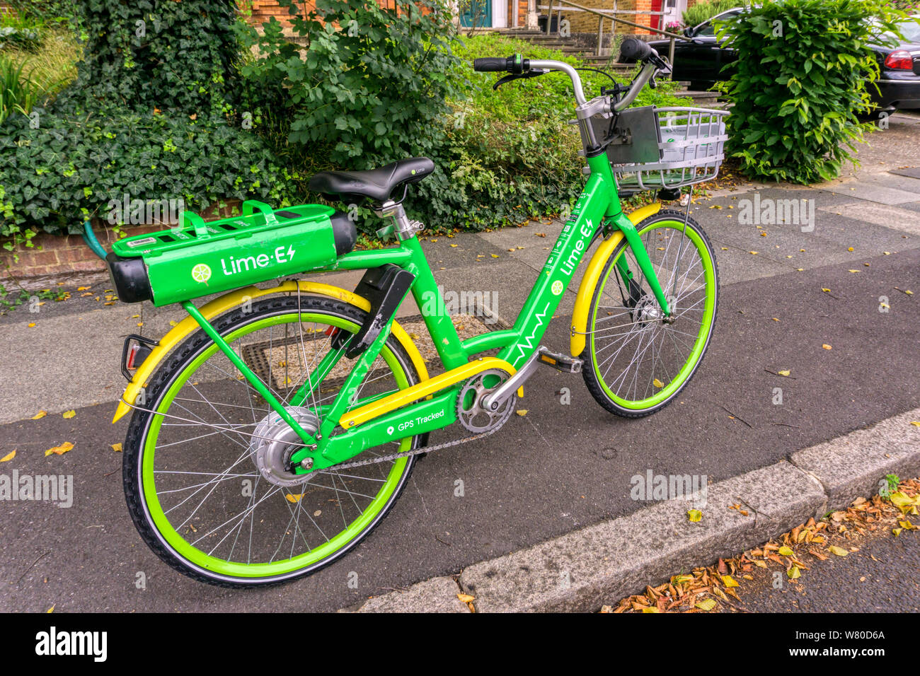 Un calce-e bicicletta elettrica parcheggiata in una strada suburbana. Foto Stock