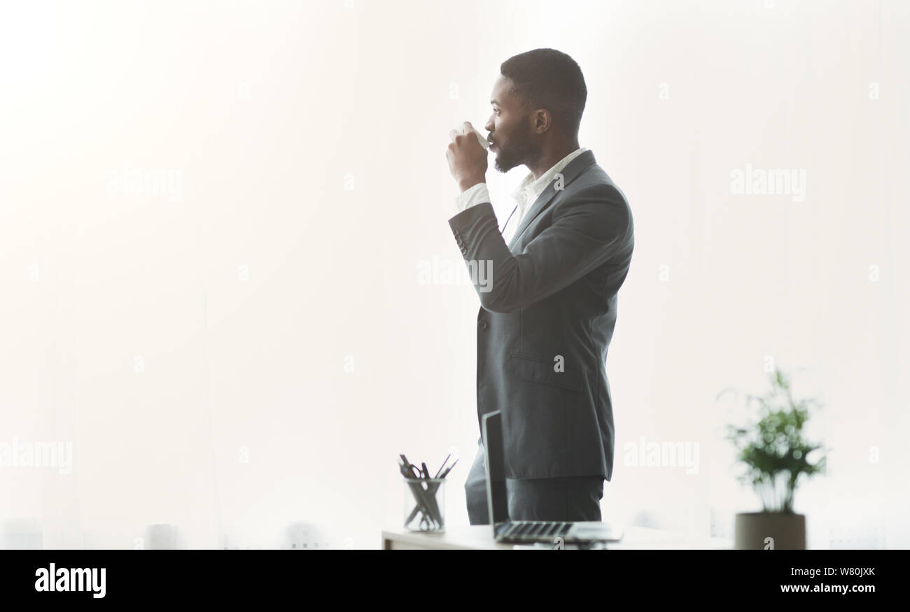 African American businessman godendo cityview dalla finestra in ufficio Foto Stock