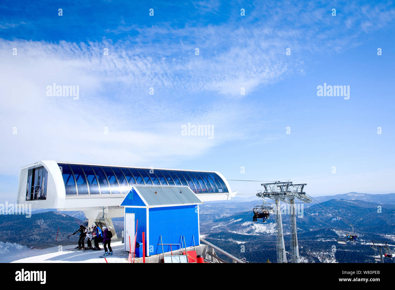 Persone su un impianto di risalita e la vista del bel cielo azzurro e montagne d'inverno. Foto Stock