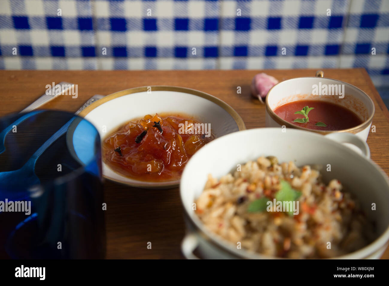 Pomodoro italiano zuppa di riso marrone risotto papaia dessert piatti di porcellana posate in argento biancheria blu igienico. Rio de Janeiro, Brasile. Durante l'anno 2019. Foto Stock