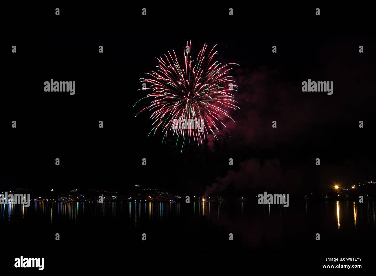 Bacoli, Napoli, 6 agosto 2019. I fuochi d'artificio dipingono il cielo in vari colori e sono riflesse nel lago Miseno, creando un panorama mozzafiato. Foto Stock