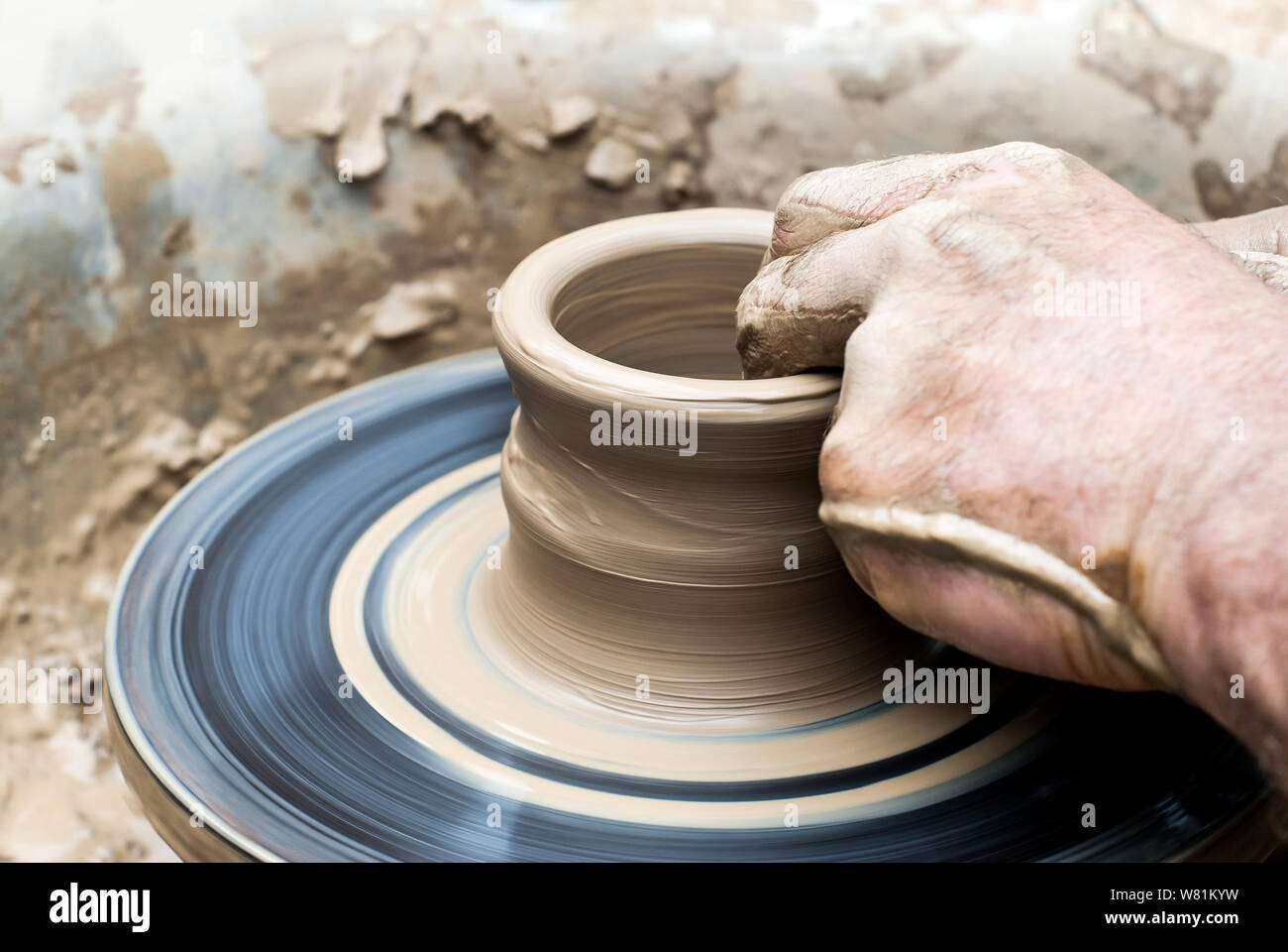 Gli uomini con le mani in mano facendo una tazza di argilla su un tornio del vasaio Foto Stock