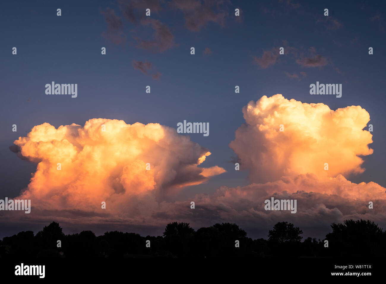 Due nuvole temporalesche sono edificazione nella incudine producendo fulmini e tuoni e grandine Foto Stock