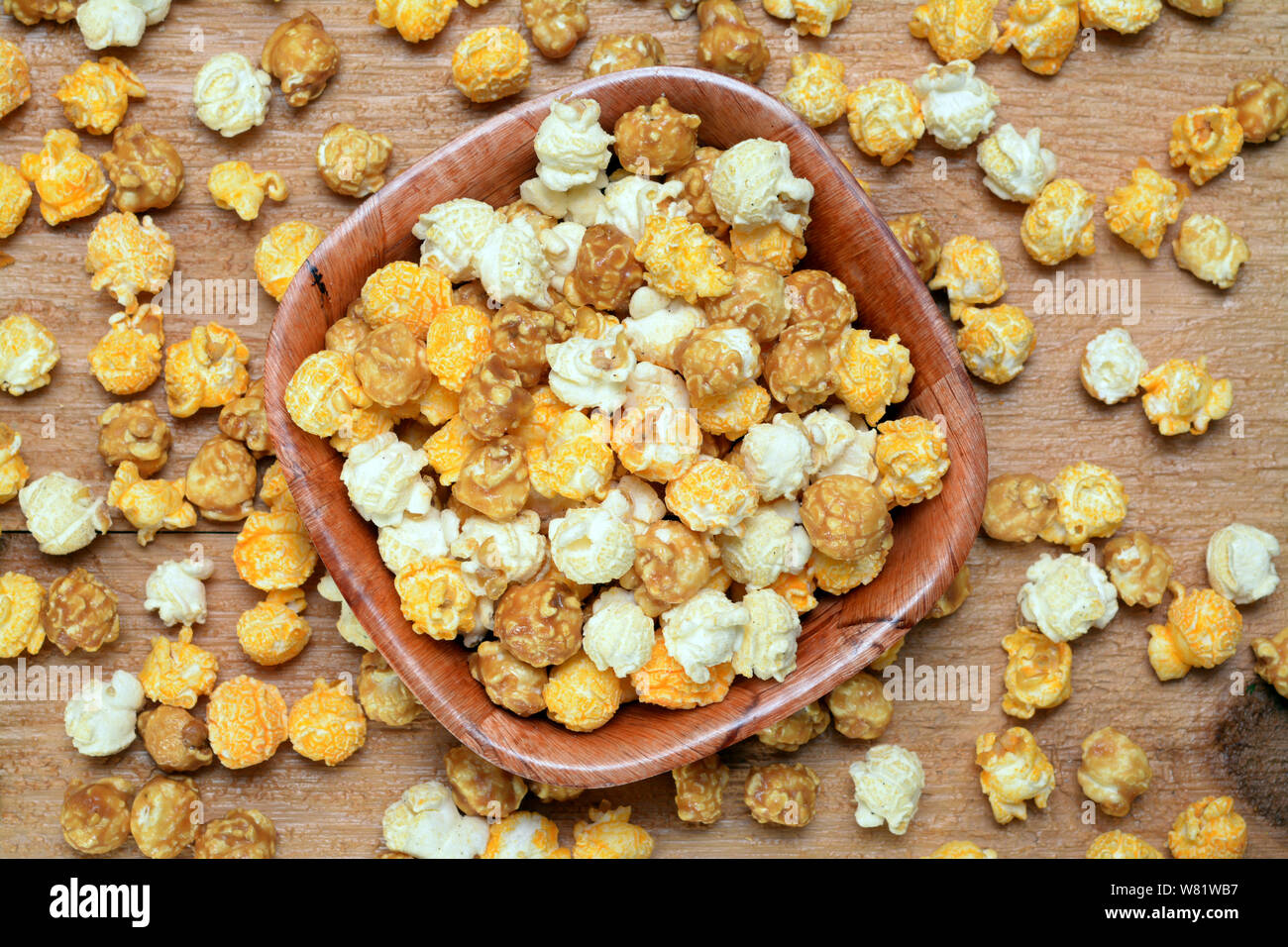 Popcorn caramellato in ciotola di legno su tavola Foto Stock