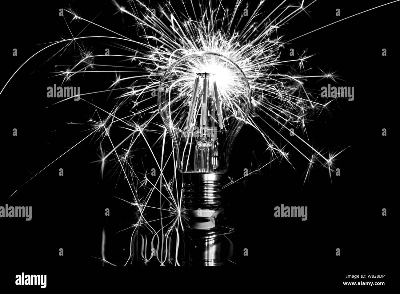 Fuochi d'artificio sparkler dietro la luce di LED lampadina - bianco nero Foto Stock