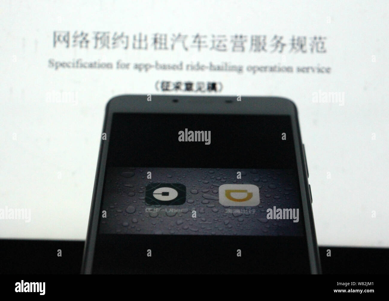 --FILE--un cinese telefono cellulare utente guarda le icone delle applicazioni mobile di taxi-salutando apps Didi Chuxing, destra e Uber sul suo smartphone in Jina Foto Stock