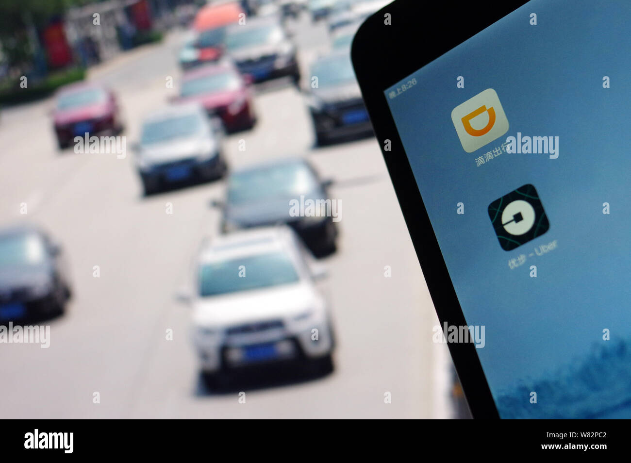 --FILE--un cinese telefono cellulare utente guarda le icone delle applicazioni mobile di taxi-salutando apps Didi Chuxing, superiore e Uber sul suo smartphone in Jina Foto Stock