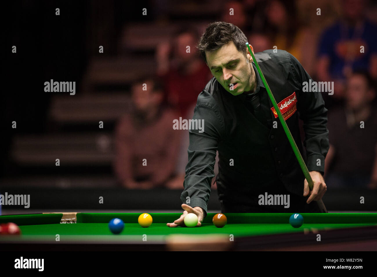 Ronnie O'Sullivan di Inghilterra ritiene che un colpo di Neil Robertson di Australia nel loro quarterfinal match durante il 2017 Dafabet Masters snooker tourn Foto Stock