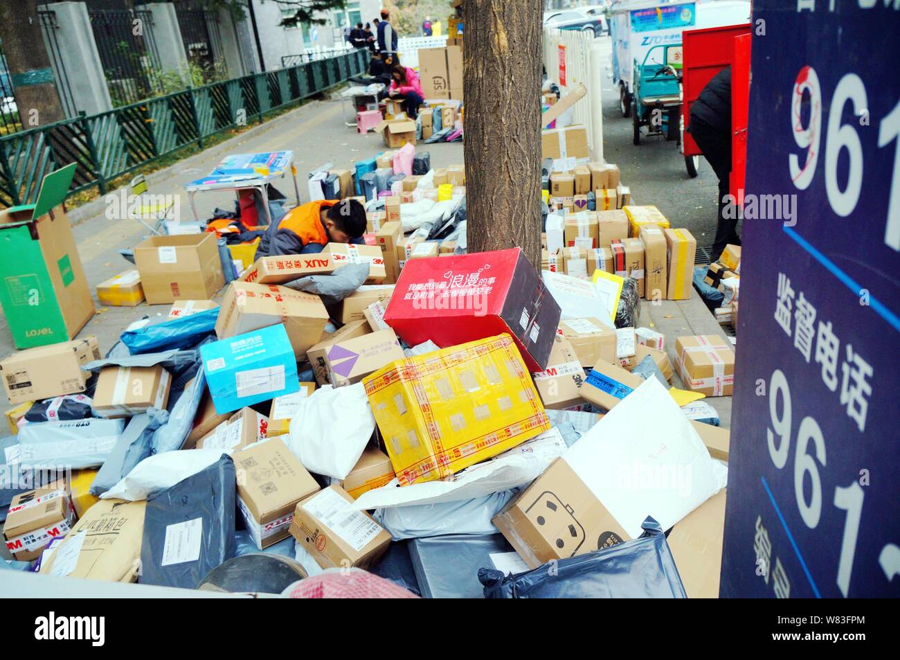 --FILE--studenti cinesi cerca in una massa di pacchi, la maggior parte delle quali sono camere singole al giorno online shopping, di fronte ad una porta di una università in Beijin Foto Stock