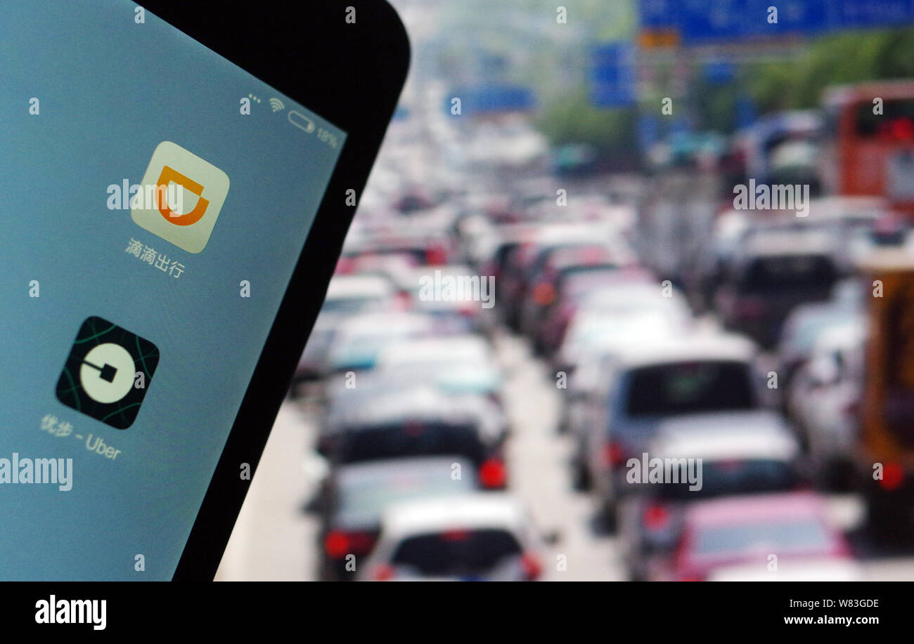 --FILE--un cinese telefono cellulare utente guarda le icone delle applicazioni mobile di taxi-salutando apps Didi Chuxing, superiore e Uber sul suo smartphone in Jina Foto Stock