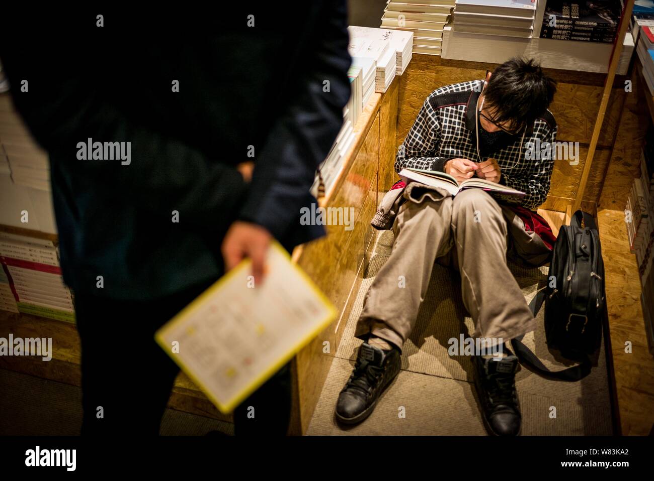 Un bookworm spende la notte in una 24-ora bookstore che offre servizio sleepover nella città di Hefei, Cina orientale della provincia di Anhui, 9 dicembre 2016. Di sempre Foto Stock